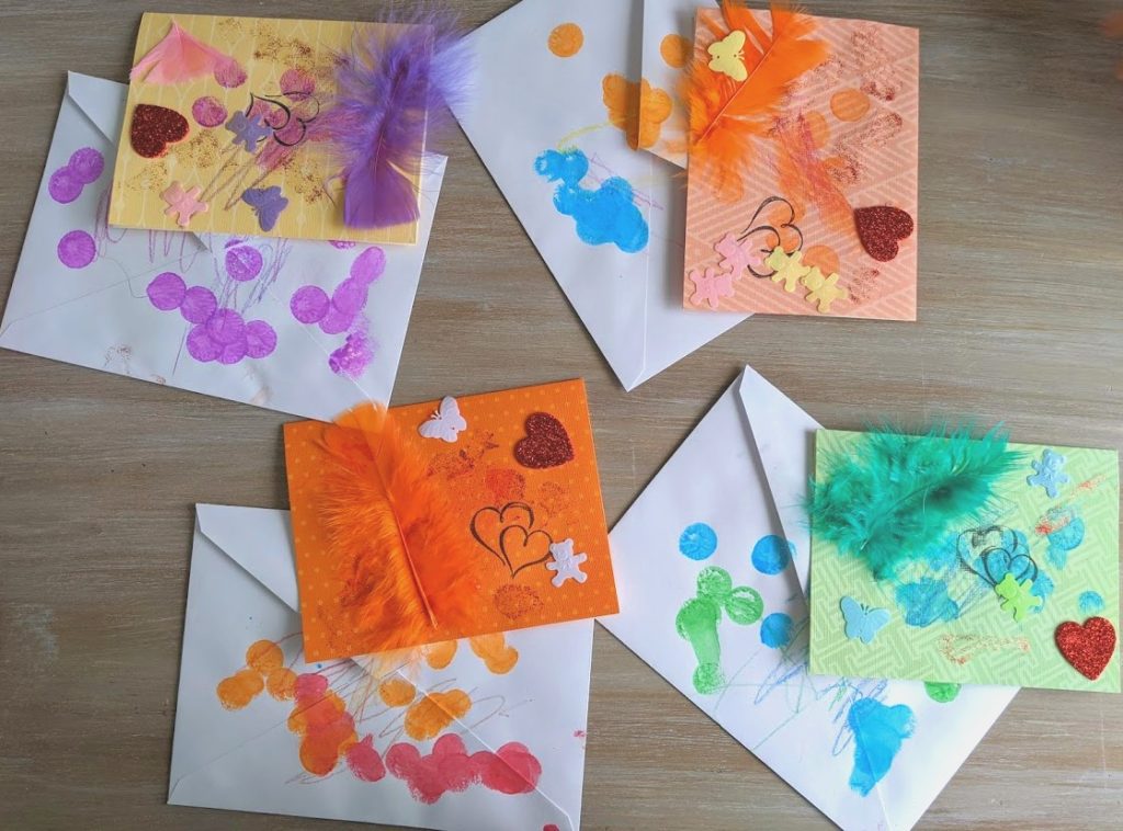 Four completed quarantine letters with decorated envelopes to match. All cards are decorated with feathers, paint, stickers, confetti and glitter. 